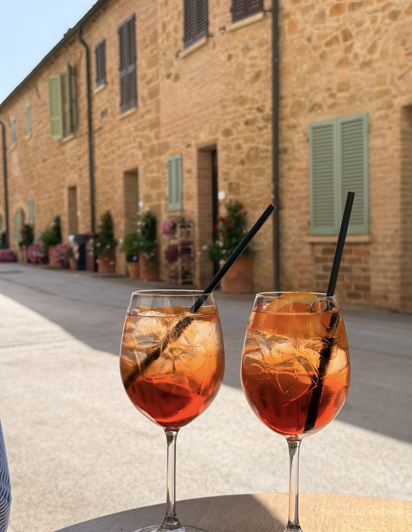 Two Aperol spritz on a sunlit table
